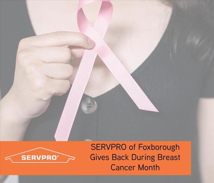 Holding Pink Ribbon with orange text box and SERVPRO logo